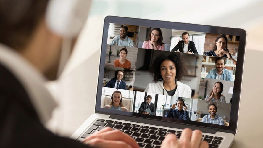 Hombre mirando una pantalla llena de colegas en una conferencia telefónica: investigación de pulso de experiencia de empleado