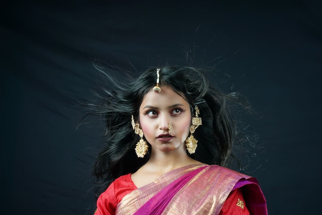 Mujer con sari tradicional y joyería dorada.