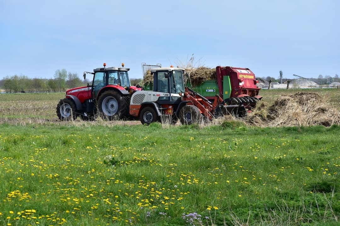 Tractores trabajando en el campo con paja.