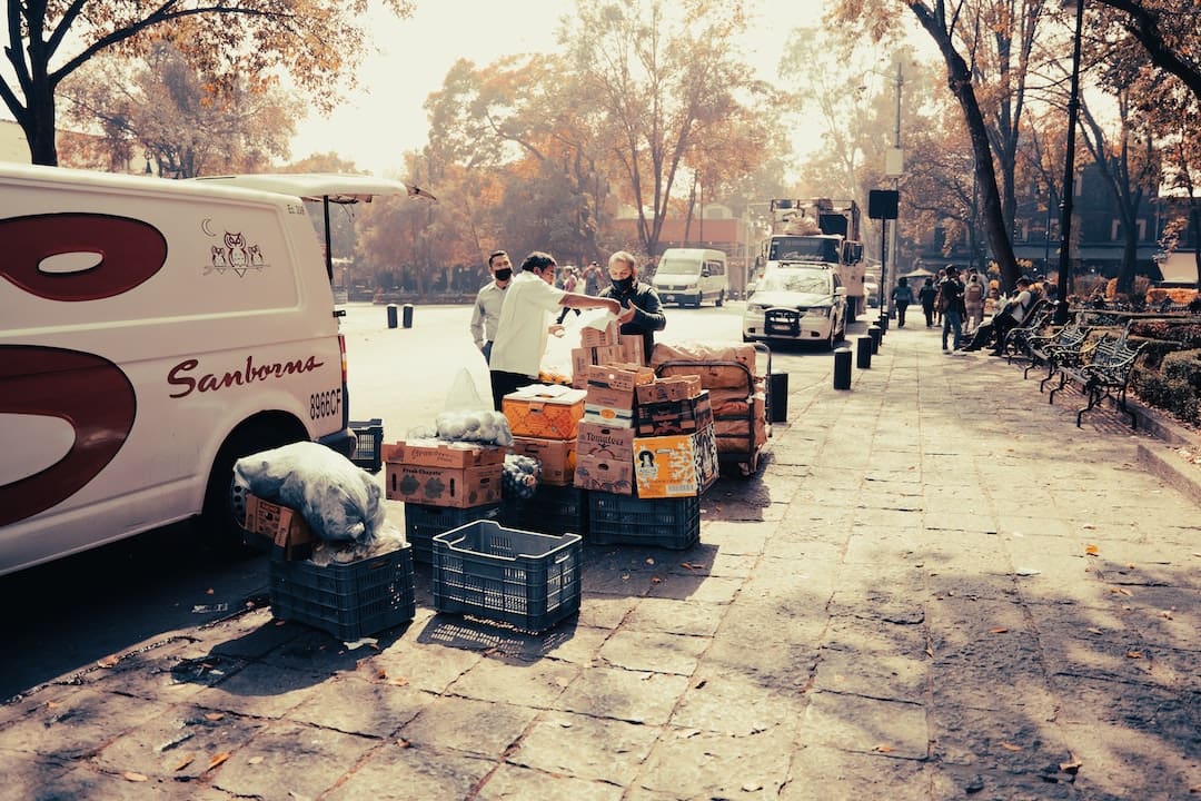 Personas descargando cajas de un camión blanco.